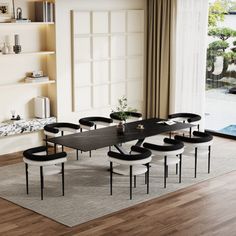 a dining room table with chairs and a rug on the floor in front of it