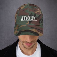 "An awesome camouflage print JROTC hat perfect for Junior ROTC Cadets and their friends and family. Makes a great gift for showing off your love for JROTC with pride. This is a great quality hat with an embroidered JROTC logo- not a cheap print like my competitors put out. This one's got a low profile with an adjustable strap and curved visor. * 100% chino cotton twill * Unstructured, 6-panel, low-profile * 3 ⅛\" crown * Adjustable strap with antique buckle * Head circumference: 20 ½\" - 21 ⅝\"" Camo Suit, Boykin Spaniel, Personalized Hats, Camo Hats, Classic Hats, Fishing Hat, Embroidered Caps, Camo Colors, Embroidered Hats