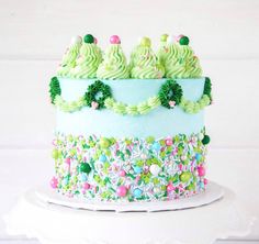 a multi layer cake decorated with green frosting and sprinkles