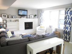 a living room filled with furniture and a flat screen tv mounted on the wall above a fireplace