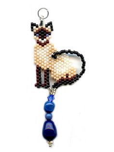 a beaded keychain with a llama on it and two beads attached to it