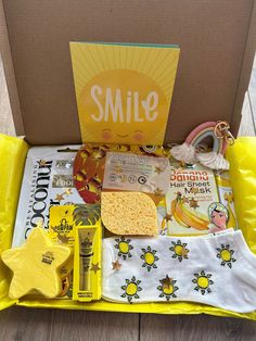 an open box with various items in it sitting on the floor next to a sign that says smile