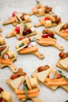 cheese and vegetables are arranged on wooden cutting boards for food trays or appetizers