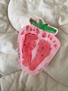 a child's hand and foot print made out of paper on a white sheet