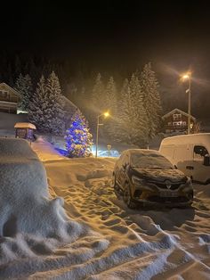 two cars parked in the snow at night