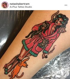 a woman with a cat and dog tattoo on her leg