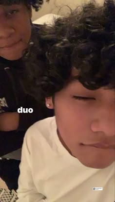 two young boys with curly hair sitting next to each other