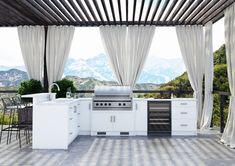 a large outdoor kitchen with an oven, sink and counter tops on the outside patio