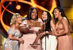 four women on stage at an awards show