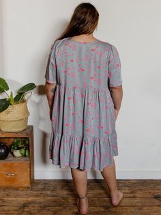 In a flowy tencel with a pop of pink, this relaxed fit mini dress features bell sleeves, a cute ruffle, hidden pockets, and a decorative tie bodice. A generous fit and above the knee cut make this a mini dress anyone can pull off! Fit Note: Designed to be roomy and flowy - those that prefer a more fitted garment or that are in between sizes will want to size down 100% Tencel Hidden pockets Easy fit Length of size 2X is 42" from top of bodice Made fair trade in India by one of our longstanding pr Spring Rayon Dresses With Pockets, Spring Dresses With Ruffle Hem And Relaxed Fit, Spring Tiered Dress With Pockets, Relaxed Fit Short Sleeve Dresses With Ruffle Hem, Casual Mini Dress With Ruffles And Relaxed Fit, Spring Mini Dress With Ruffles And Relaxed Fit, Casual Flowy Knee-length Tiered Dress, Relaxed Fit Mini Dress With Ruffles For Spring, Casual Pink Tiered Dress