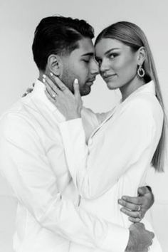 a black and white photo of a couple embracing each other with their arms around one another