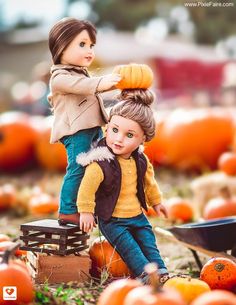 two dolls sitting on top of each other in front of pumpkins with the caption,