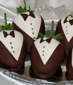 four chocolate covered strawberries in the shape of groom's suits