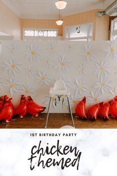 a birthday party with red balloons and white flowers on the wall, in front of a backdrop that reads 1st birthday party chicken themed