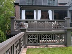 a house with a large deck and white curtains on the windows