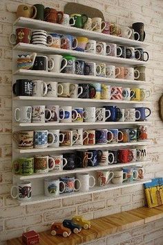 there are many coffee mugs on the shelves