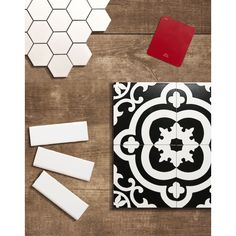 some white and black tiles on a wooden table with red square stickers next to them