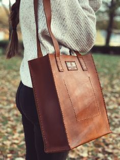 Carefully crafted and stitched by hand in the highlands of Ecuador with full grain leather. The natural imperfections of the leather make each piece unique and full of character. Our Leather Tote bag was designed in small batches to withstand the everyday use, from a walk to the park to a long day at work. Bring all your favorite essentials and get ready for a lifetime of adventures. Measurements: Size 14" (35.56 cm) tall x 12" (30.48 cm) wide x 5" (12.7 cm) deep **Leather is a natural material Square Leather Backpack For Travel, Rectangular Soft Recycled Leather Bag, Brown Leather Strap Satchel, Brown Leather Strap Satchel For On-the-go, Everyday Bags With Recycled Leather And Leather Lining, Vegetable-tanned Leather Shoulder Bag For Travel, Rectangular Recycled Leather Bag, Brown Leather Shoulder Bag With Waxed Finish, Natural Leather Shoulder Bag With Leather Handles