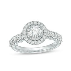 a white gold ring with diamonds on the band and an oval center stone surrounded by small round