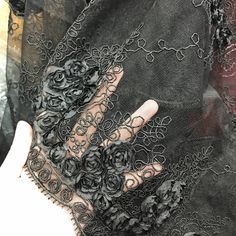 a woman's hand with black lace and flowers on it, in front of an image of her left hand