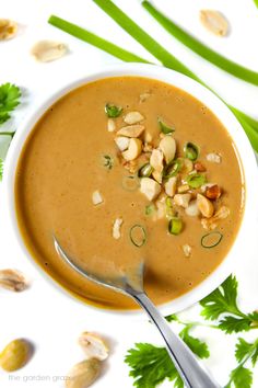 a white bowl filled with soup and garnished with nuts