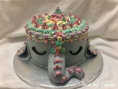 the cake is decorated with an elephant's head and flowers on its top,