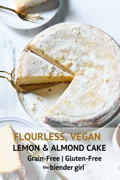 a lemon and almond cake on a white plate with a slice missing from the cake