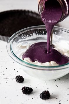 a bowl filled with whipped cream and blackberries