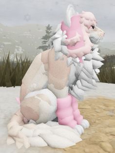 a stuffed animal sitting on top of a pile of snow next to grass and trees