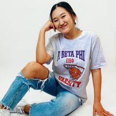 a woman sitting on the floor with her hand under her chin and smiling at the camera