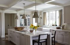 a large kitchen with white cabinets and an island in the middle is decorated with sunflowers