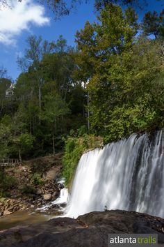 a large waterfall in the middle of a forest