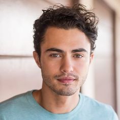 a close up of a person wearing a t - shirt and looking at the camera