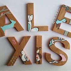 the letters are made out of wood and have animals painted on them to spell their names