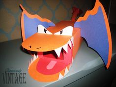 an origami dragon head with its mouth open and it's tongue out