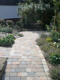 a brick path in the middle of a garden