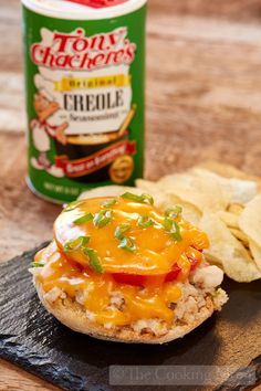 an open faced sandwich with cheese and tomatoes on it, next to tortilla chips