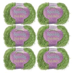 six spooly dish yarns in green grass with pink labels on the front