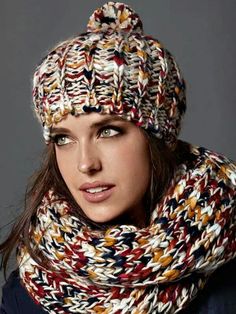 a woman wearing a multicolored knitted hat with a scarf around her neck