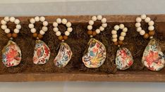 an assortment of decorative items displayed in a wooden box with moss and flowers on it