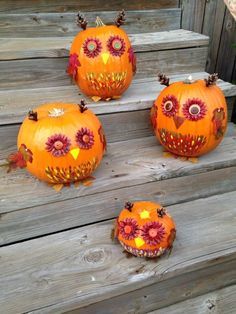 three pumpkins decorated like owls sitting on some steps