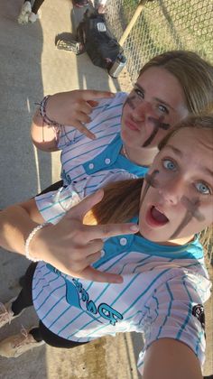 two women are posing for the camera with their arms around each other and one woman has her face painted