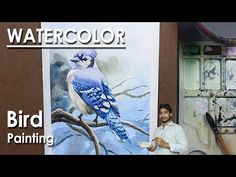 a man sitting in front of a blue bird painting