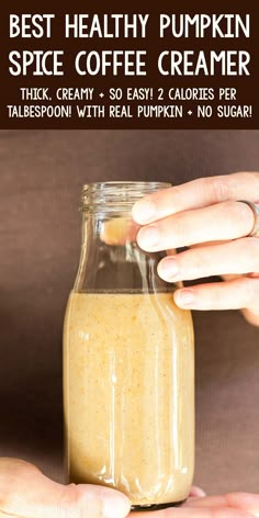 a person holding a glass jar filled with coffee creamer and text overlay reads best healthy pumpkin spice coffee creamer