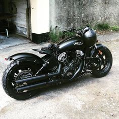 a black motorcycle parked in front of a building