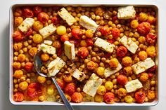 a white dish filled with chickpeas, tomatoes and tofu