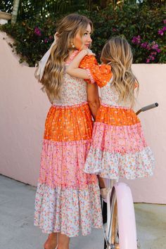 The patchwork dress of your DREAMS now available in bright and bold colors! The Emily Dress features the most fashion forward design, consisting of orange, pink, and stunning floral fabric. She also has an Ivy Favorite smocked bodice, tiered skirt, and dainty puff sleeves. This dress screams, "Ready for Summer" and will be your go-to dress for all your upcoming adventures! Available in size XXS, XS, S, M, L, XL, XXL, 1X, 2X, 3X, 4X, & 5X + kids! Mommy And Me Dress Pattern, Tiered Dress Outfit, Ella Outfit, Orange Dress Outfits, Flora Skirt, Daughter Fashion, Mommy And Me Photo Shoot, Ivy City Co, Mommy And Me Dresses