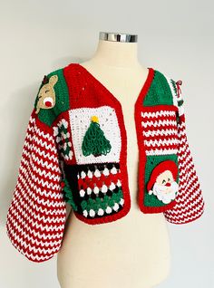 a white mannequin wearing a red and green sweater with christmas decorations on it