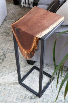 a wooden table sitting on top of a metal frame in a living room next to a couch