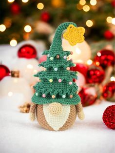 a crocheted christmas tree on top of a stuffed animal in front of a christmas tree